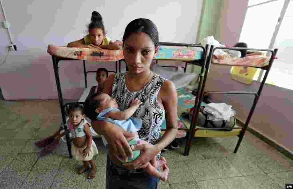 Una mujer intenta dormir a su bebé en un albergue hoy, lunes 03 de octubre de 2016, en la ciudad de Guantánamo (Cuba), ante la proximidad del huracán Matthew. Seis provincias de Cuba se encuentran bajo "alarma ciclónica" a la espera del potencial impacto