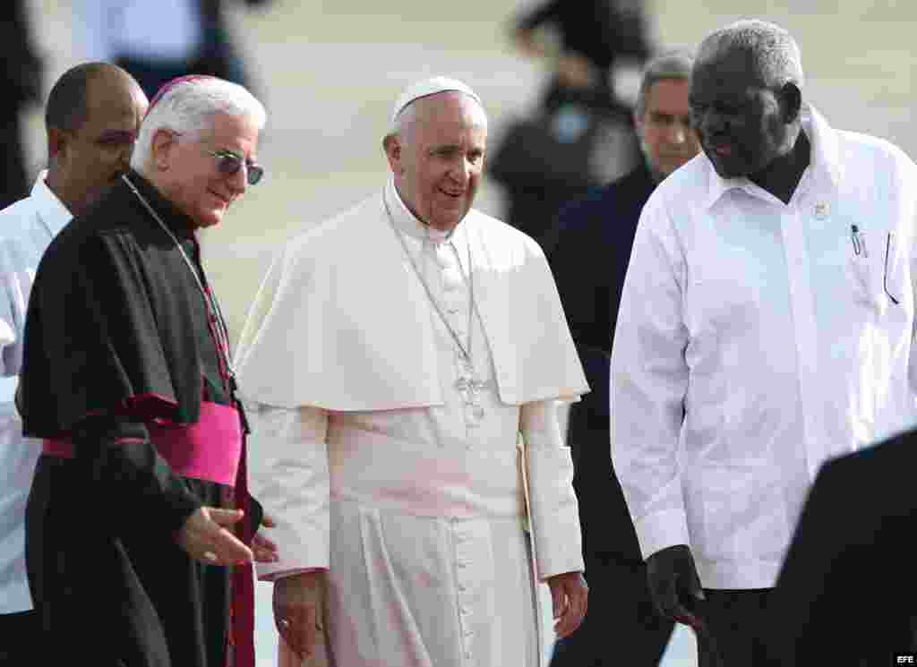 El papa Francisco (c) recibido por el arzobispo Dionisio Guillermo García (i) y el presidente del Parlamento cubano, Esteban Lazo (d).