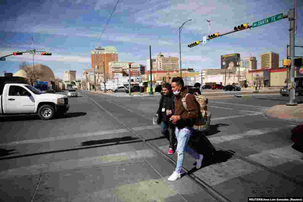 Yunior Espinosa y Pedro Luis Ruiz, migrantes cubanos bajo el Programa de Protección de Migrantes (MPP) por sus siglas en inglés, caminan hacia la terminal de auto bus después de cruzar desde México la frontera hacia El Paso Texas, Estados Unidos y poder continuar sus trámites de asilo. Foto: tomada el 11 de marzo de 2021 por REUTERS/José Luis González.